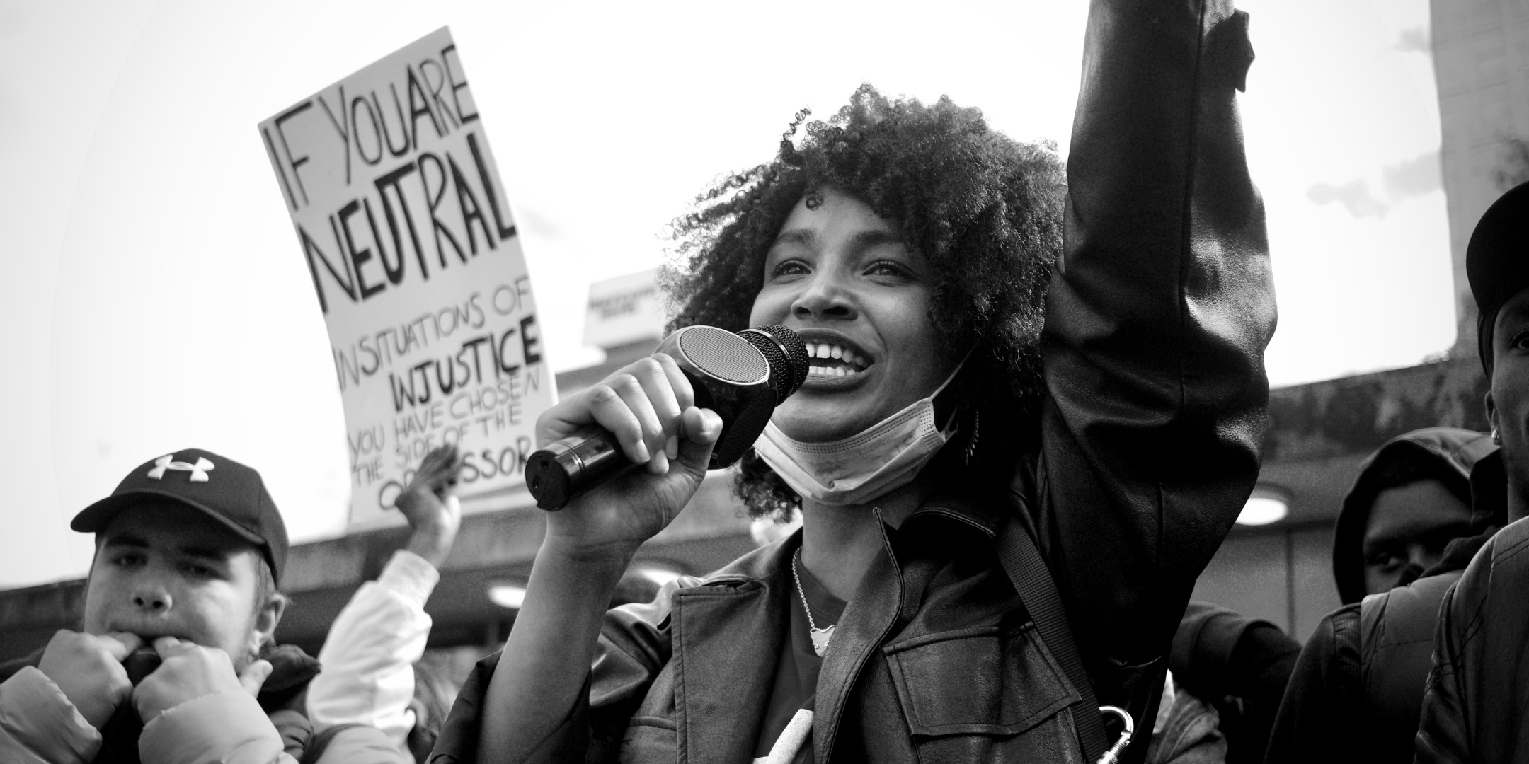 Black Woman cheering into a microphone at a demonstration
